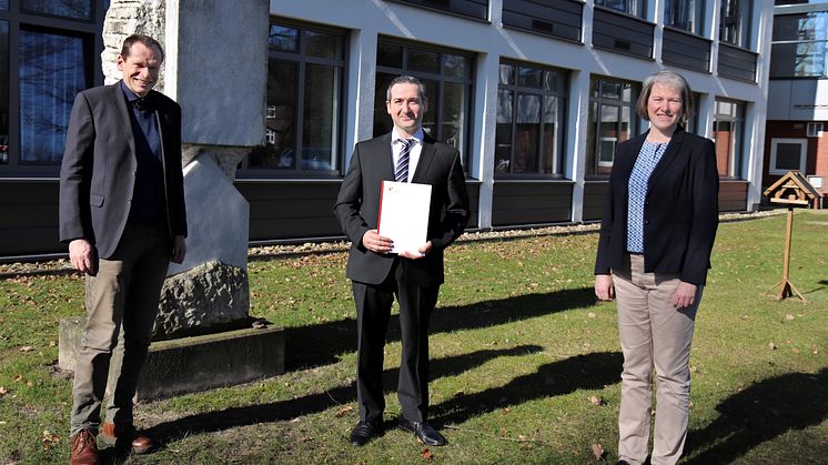 Dr. Rami Georg Johann (m.) zusammen mit seinem Doktorvater Prof. Dr. Peter Nitschke bei der Übergabe der Promotionsurkunde durch Universitätspräsidentin Prof.in Dr.in Verena Pietzner.