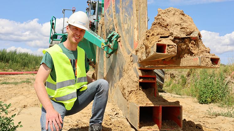 Projektleiter Bernd Igelbüscher zeigt den Rohr-Pflug. Das Pflug-Schwert neben ihm verschwindet komplett unter der Erde, um die Rohre für die neue Kabelleitung bei Bachl in den Boden zu bringen.