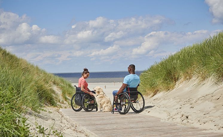 Langeoog_Paar_mit_Rollstühlen_in_den_Dünen_unterwegs