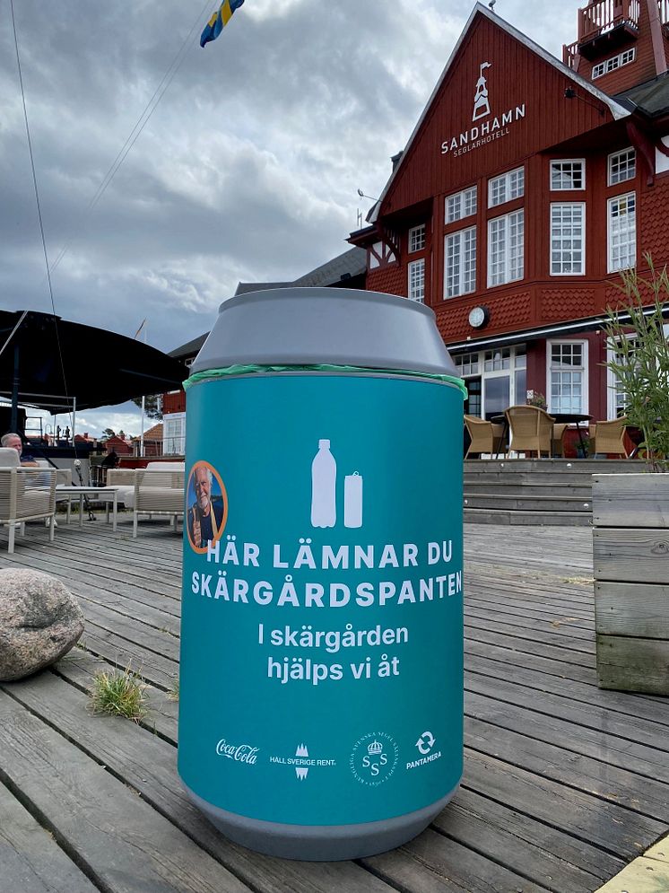 Bild på pantkärl framför ett rött hus