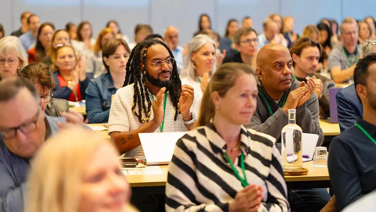 Audience at the 38th AOECS Annual Conference in Amsterdam. Delegates  applauding during a conference session.