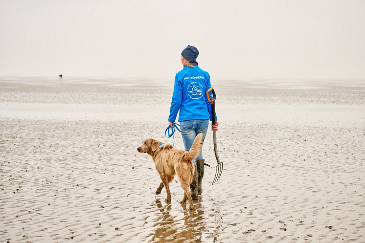 Cuxhaven_Otterndorf_Die_Wattführerin_mit_ihrem_Hund_im_Watt.jpg