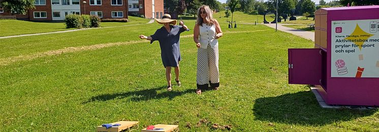 Två kvinnor spelar cornhole som de har hyrt gratis via den rosa Pifflboxen i Sundsvall.