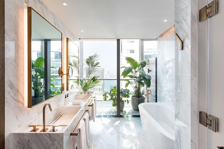 Ein luxoriöses Badezimmer mit viel Marmor, einem Doppelwaschtisch und designorientierten Armaturen von Axor