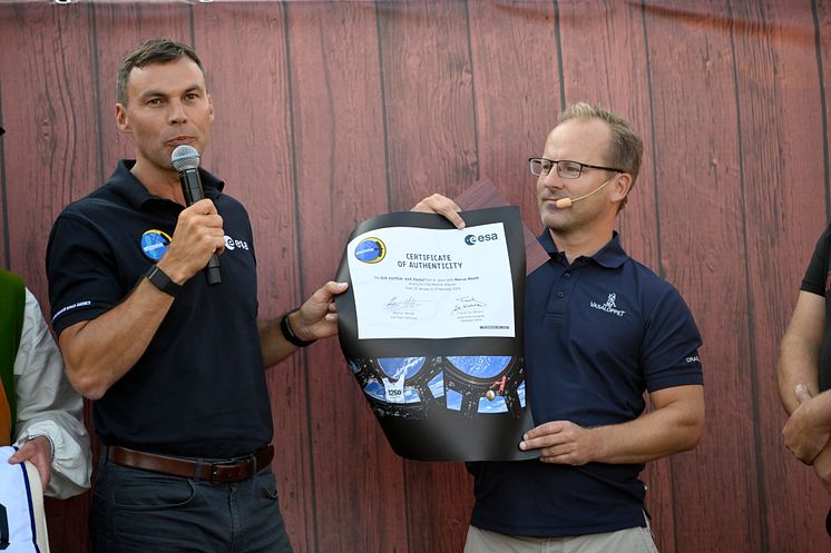 Astronaut Marcus Wandt lämnar över Vasaloppsmedalj och nummerlapp