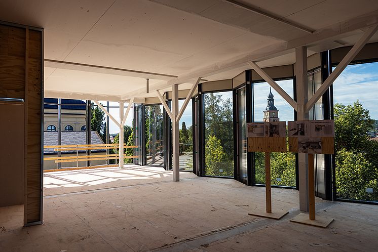 Interiör på en byggnadsarbetsplats med stora glaspartier.