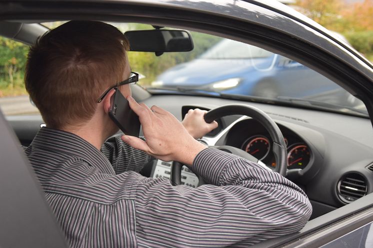 Driver using a mobile phone at the wheel