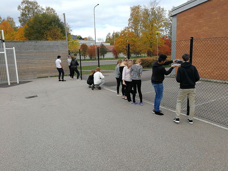 Elever på Erlaskolan i Falun mäter ute på skolgården.