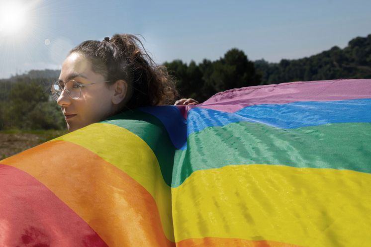 kvinna haller prideflagga