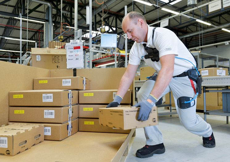 An Audi employee uses the exoskeleton when packing car components in CKD (completely knocked down) logistics at the Ingolstadt plant