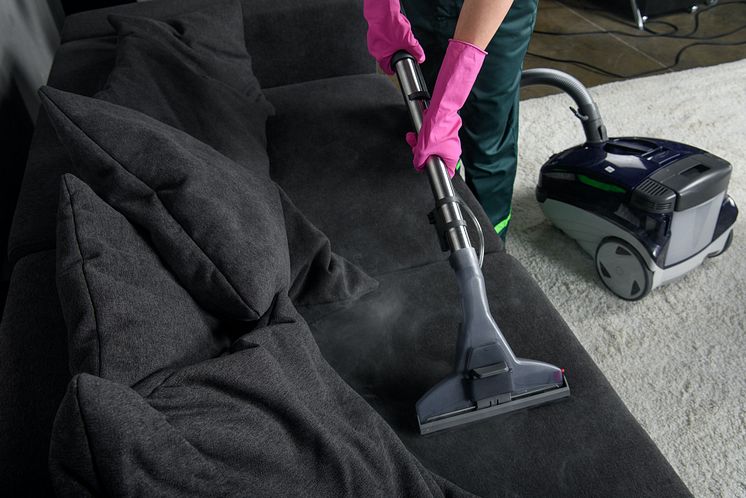 cropped-shot-of-person-cleaning-sofa-with-vacuum-cleaner-upholstery-cleaning-concept