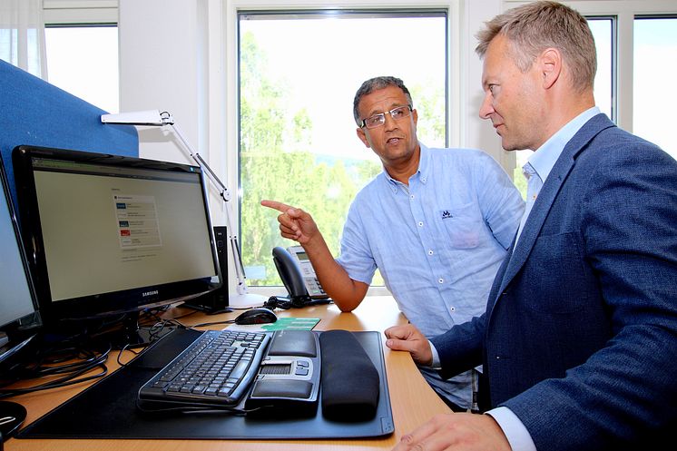 Signeringsløsningen fra Digipost letter arbeidsdagen til arkivmedarbeider Abdelilah Lemriri. Her viser han løsningen til kommunikasjonssjef Torkel Bergstøl (t.h.) i Nittedal kommune.