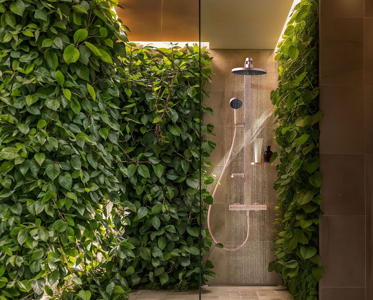 Eine Dusche mit Kopfbrause in einem Badezimmer mit vielen, grünen Pflanzen von Ideal Standard.