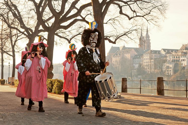 Basler Fasnacht. Tambour und Piccolospieler am Rheinufer mit dem Muenster im Hintergrund 