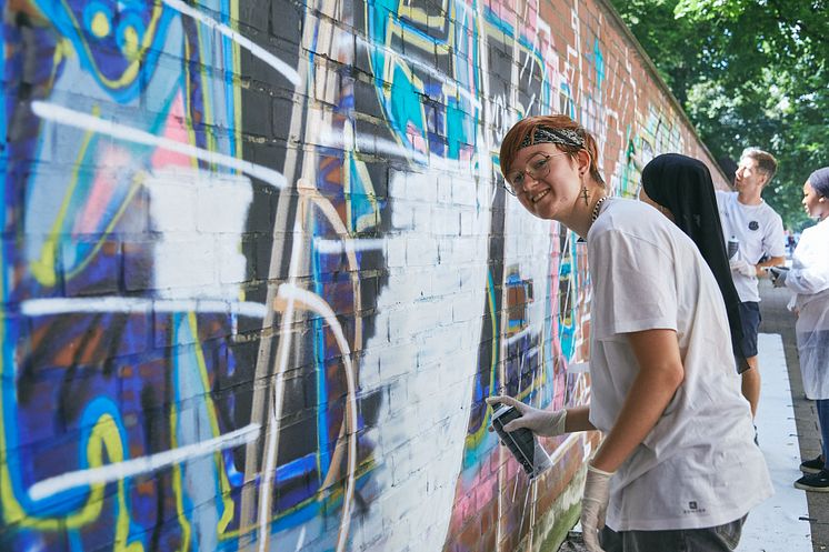 Jugendliche sprayen eine Botschaft 