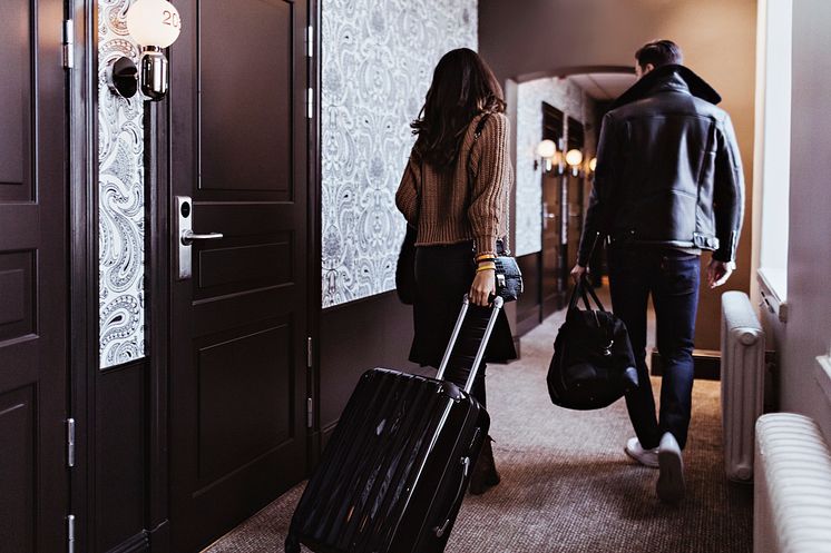THEME_TRAVEL_HOTEL_CORRIDOR_ROOMS_PEOPLE_COUPLE_WALKING_LUGGAGE_GettyImages-1241453705_Universal_Within usage period_100313-1.jpg