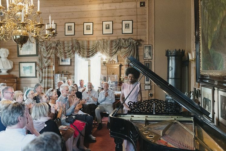 Publikum på konsert i villaen på Troldhaugen.