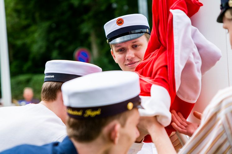 De første studenter på Tradium HTX hejser flaget foran skolen.