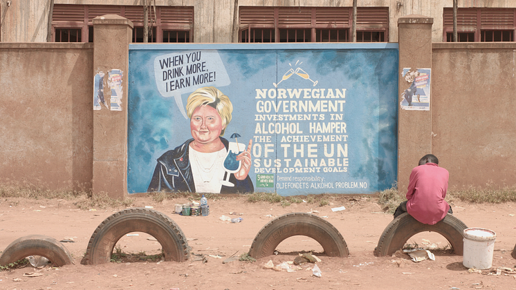 Erna Solberg på en vegg i Uganda