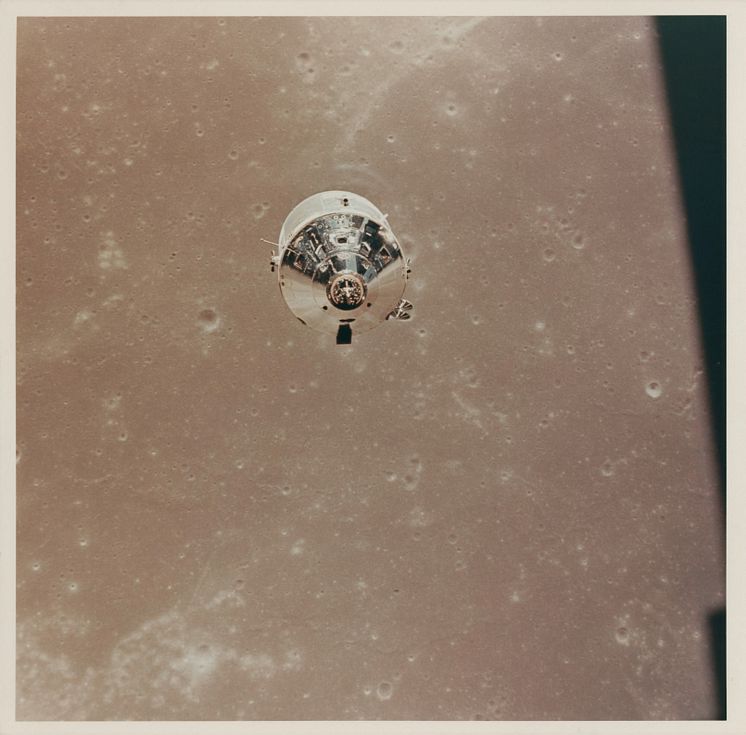 The CSM Columbia over the Sea of Fertility, as seen from the LM descending to the lunar surface.jpg
