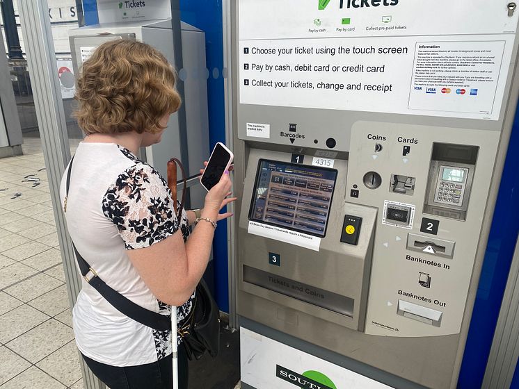 Linn Davies is guided to a ticket machine at Brighton station using the Aira app