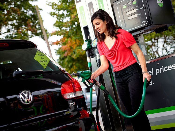 Motorist filling up at fuel station