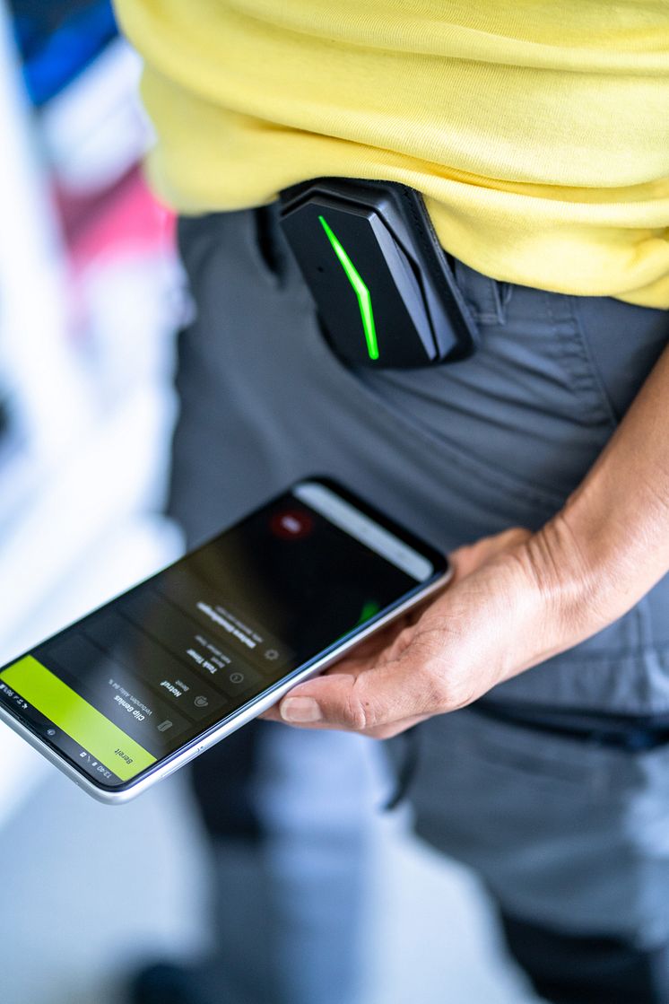 Person wears ANGEL Clip system and looks on their smartphone with ANGEL React app.jpg