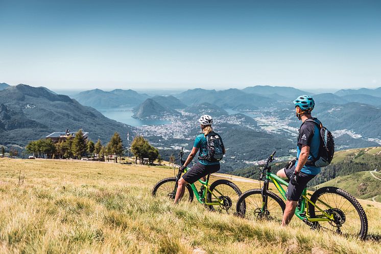 Mountainbiker geniessen das Lugano Panorama bei der Capanna Monte Bar oberhalb Capriasca 