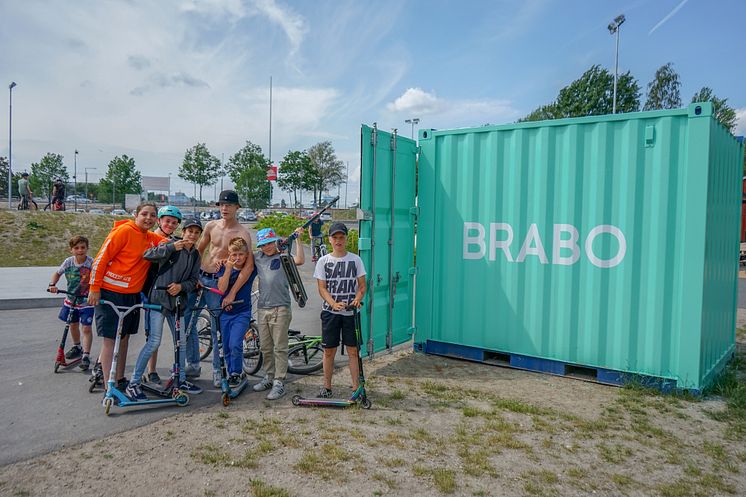 Barn och ungdomar samlade kring BRABOs utlåningscontainer i Vilunda aktivitetspark