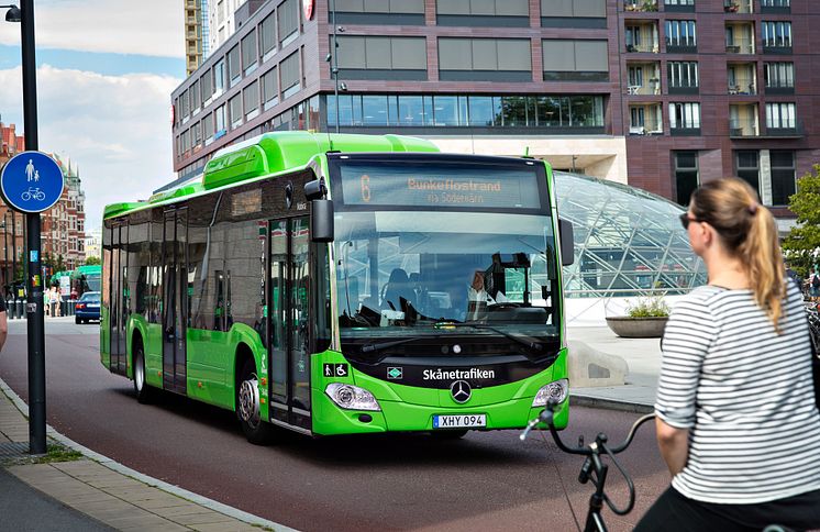 Stadsbuss med cyklist framför