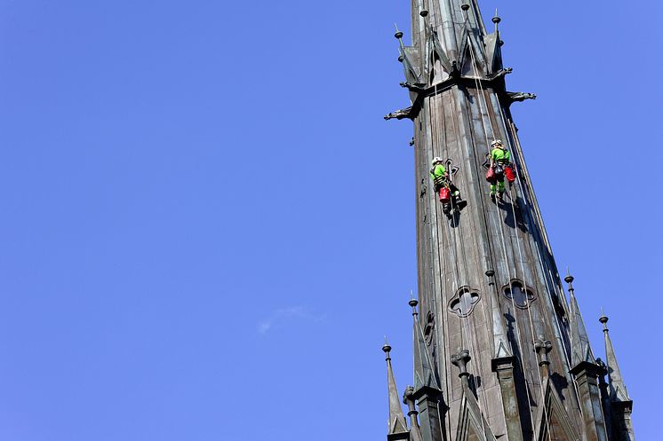 Två klättrare inspekterar tornen på Uppsala Domkyrka