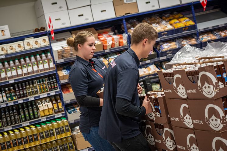 Michelle og anden elev fylder varer op.