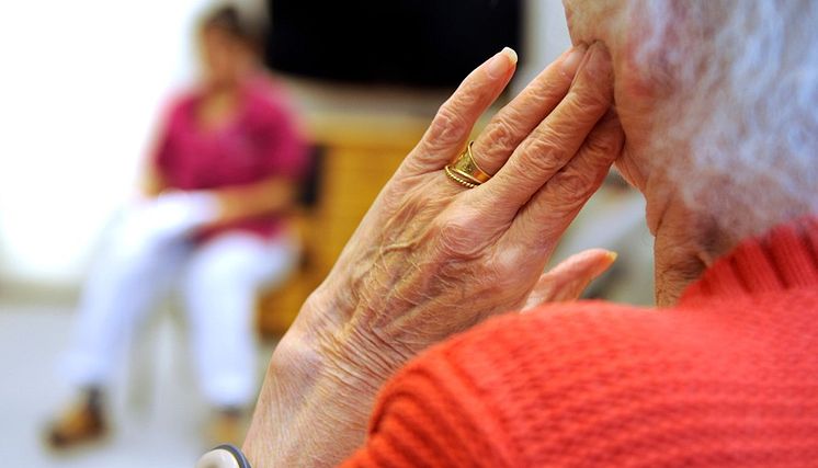 Äldre kvinna pratar med omvårdnadspersonal