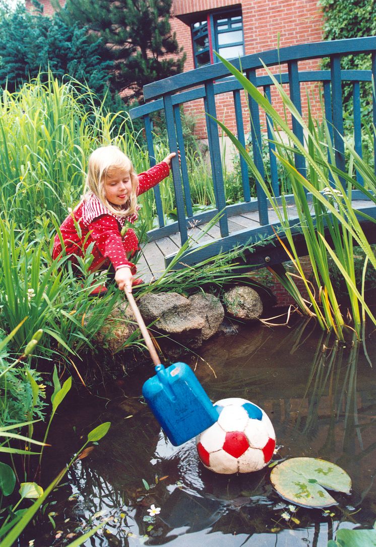 Mädchen am Gartenteich