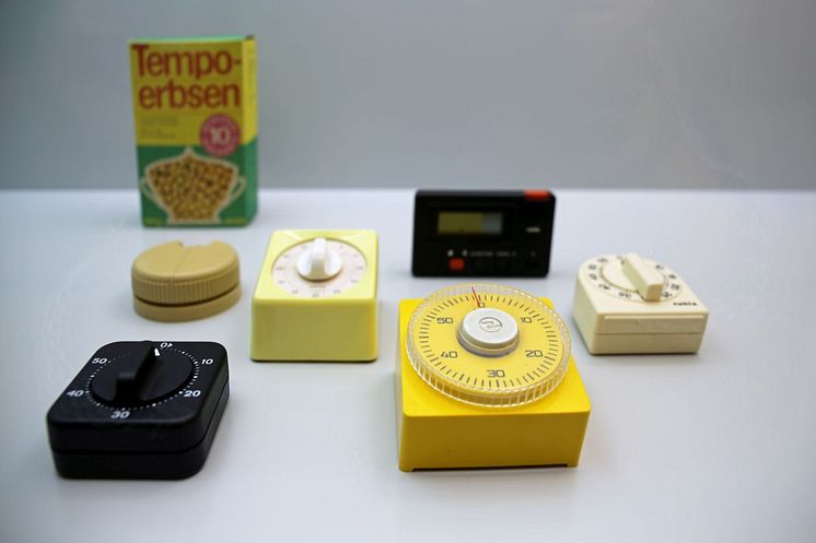 Auswahl an Eieruhren in der Ausstellung "Backen, Bügeln, Putzen, Kochen - Das bisschen Haushalt!" im GRASSI Museum für Angewandte Kunst Leipzig