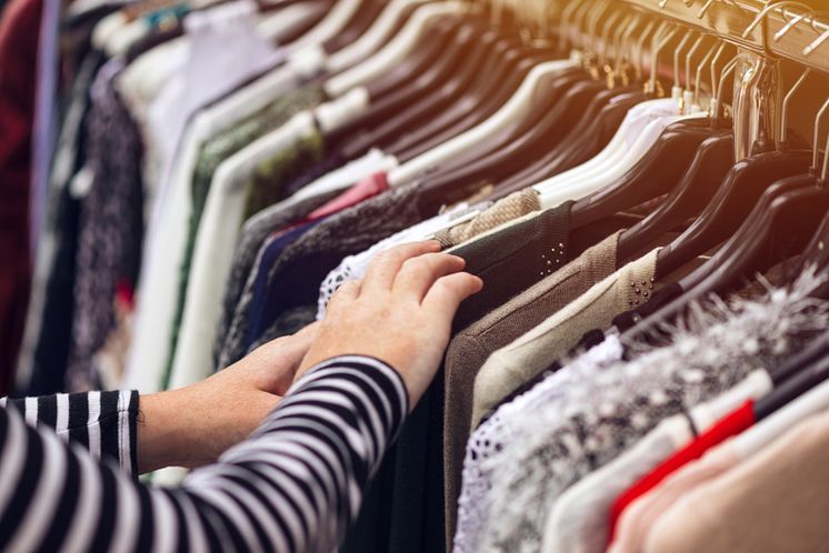 22763846-woman-browsing-through-clothing-at-second-hand-street-market