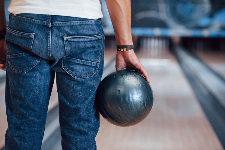 rear-particle-view-man-casual-clothes-playing-bowling-club