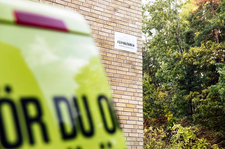Fasad med Förvaltarenskylt och skåpbil i förgrunden