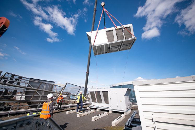 Preparatory work began in early February, with the ASHPs lifted six stories onto the roof of each building