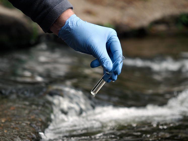 Water sample. Gloved hand into the water collecting tube. Analysis of water purity, environment, ecology_4801 x 3601 px