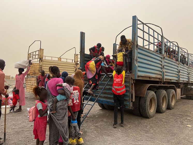 CH11013462_Save the Children staff assisting women and children board truck bound for Transit Centre 2 in Renk, South Sudan