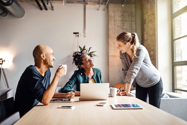 Business colleagues with coffee and laptop at meeting table_Luis Alvares_GettyImages-875611350.jpg