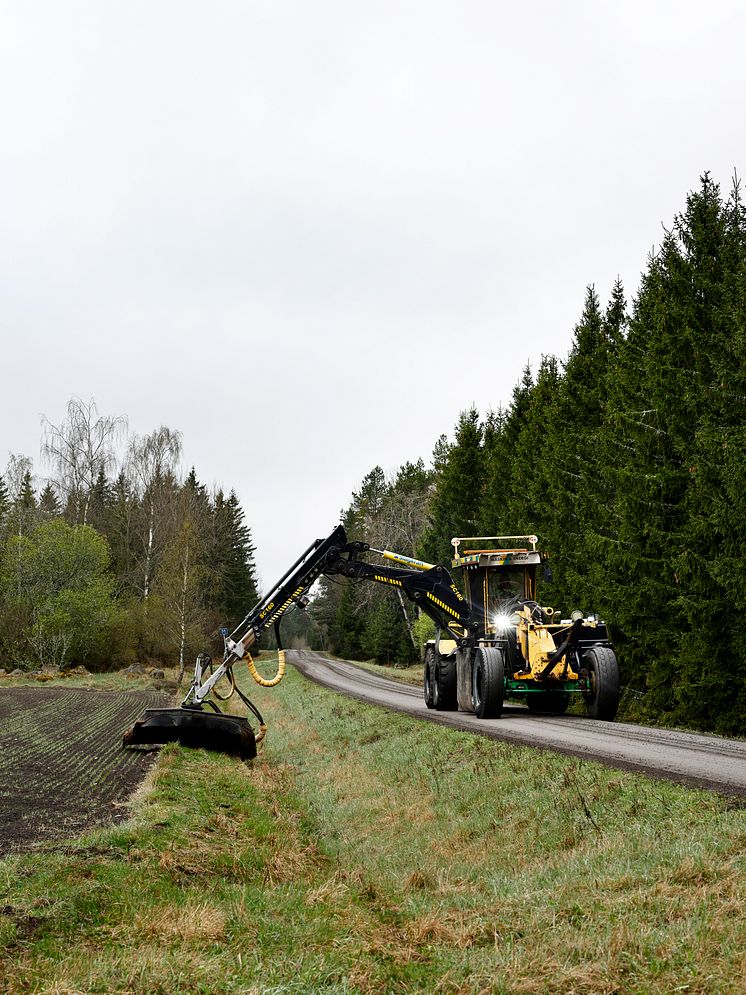 Nordverk-väghyveln med frontaggregat och kran med klippaggregat röjer 500 mil väg.