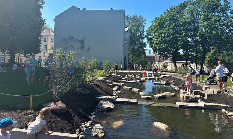 Barn leker steiner i vannet. Åpning av Klosterenga park