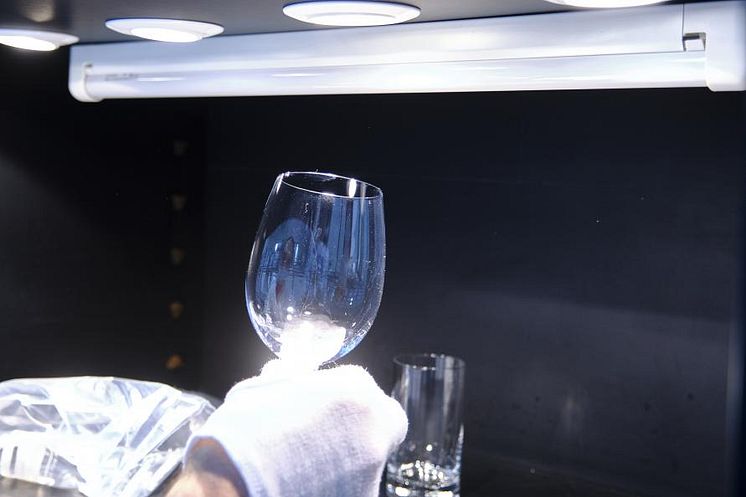 Grå hinna på glas och bestick efter disk bedöms i laboratoriets ljuskammare. 