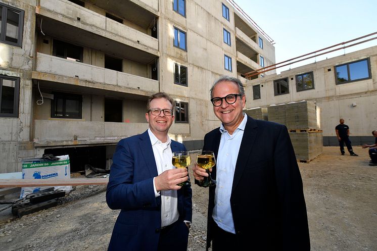 Dr. Bernd Hochberger (li.), Vorstandsmitglied der Stadtsparkasse München, stoßt zusammen mit dem Leiter des Immobilienmanagements, Michael Rubenbauer, auf das Richtfest des Neubaus in der Belgradstraße an.