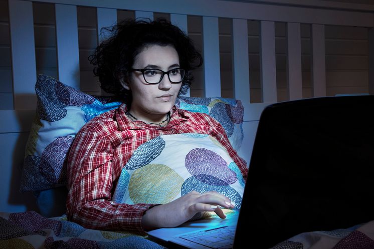 Frau im Bett mit Notebook