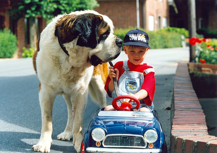 Junge mit Bernhardiner und Tretauto