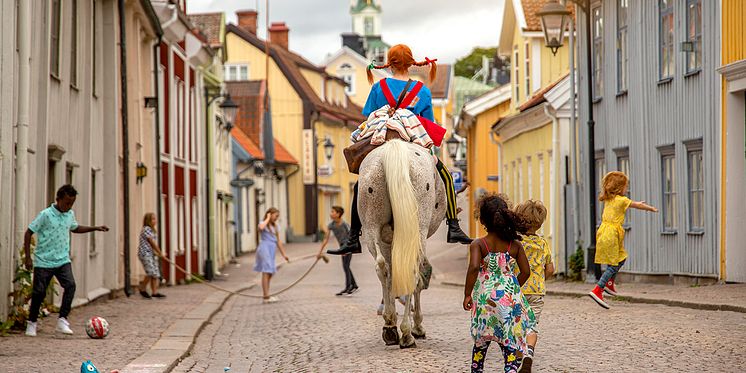 Pippi Långstrump rider genom staden