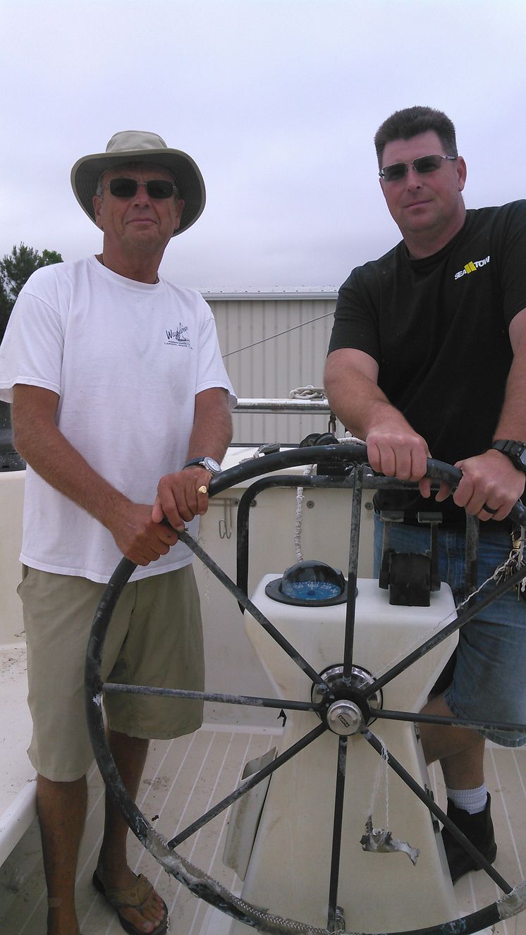 Hi-res image - ACR Electronics - Charles Nethersole with Capt. Cody Catapano, owner and captain of Sea Tow Crystal Coast, NC, on the recovered sailing catamaran Leopard.